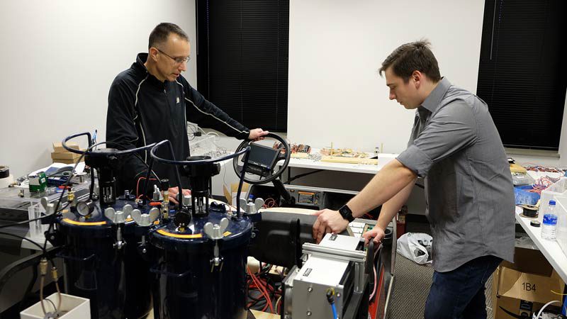 Eric Nauman, professor in mechanical engineering, biomedical engineering, and in basic medical sciences and co-founder of IFBattery, and Michael Dziekan, senior engineer for IFBattery, run tests on a membrane-free, flow battery being used to power a golf cart. Credit: Lyna Landis, Purdue Research Foundation