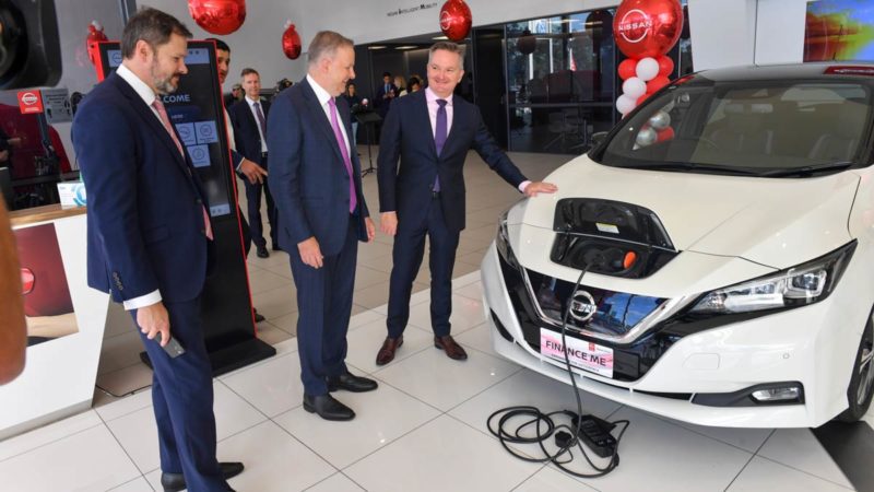 Industry minister Ed Husic, prime minister Anthony Albanese and climate and energy minister Chris Bowen inspect a Nissan Leaf in Sydney. (AAP Image/Mick Tsikas)