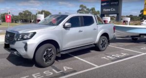 Diesel ute towing boat blocks Tesla Supercharger bays for hours